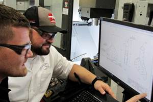 Peter Bowman (derecha) y Ben Parish verifican el plano de un accesorio tubular de torque que será mecanizado en una Haas UMC-750-2, parte de una celda de seis máquinas dedicadas al mecanizado en cinco ejes
